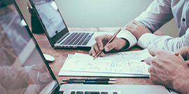 Men's hands writing with pencil on a paper